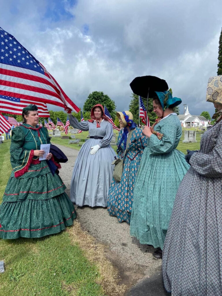 Five women garbed in 1840s dresses